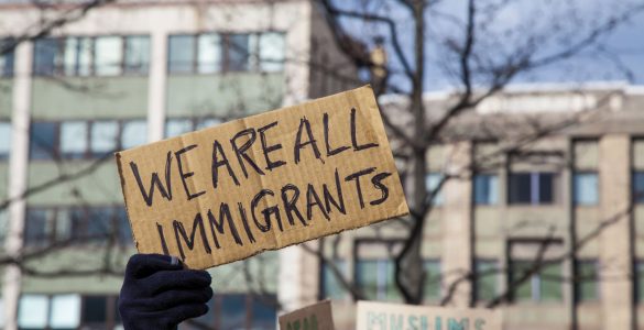 pappschild we are all immigrants vor gebaeude, foto: fotolia, jp photography